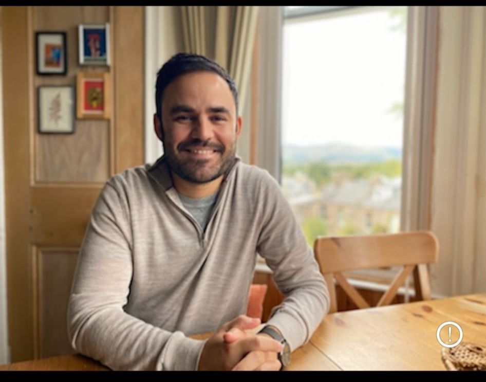 A male academic with dark hair smiling