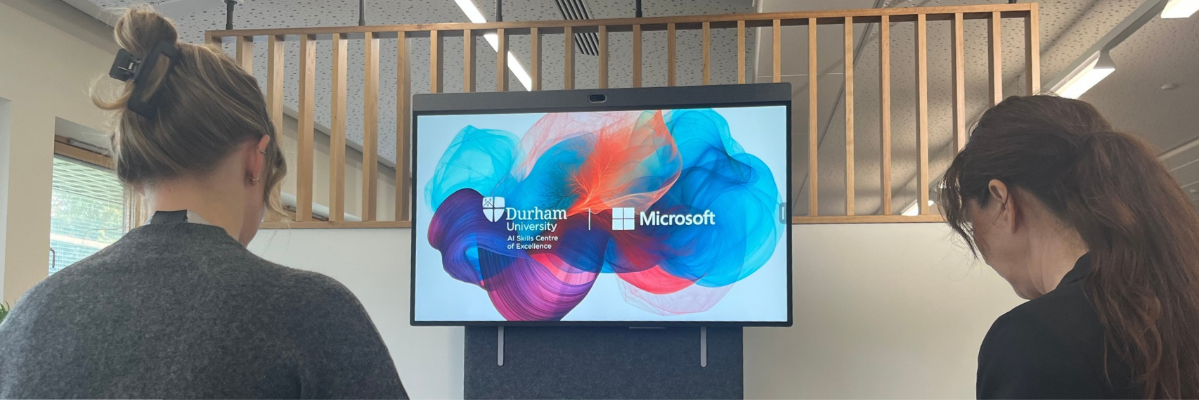 Two people looking at a presentation screen