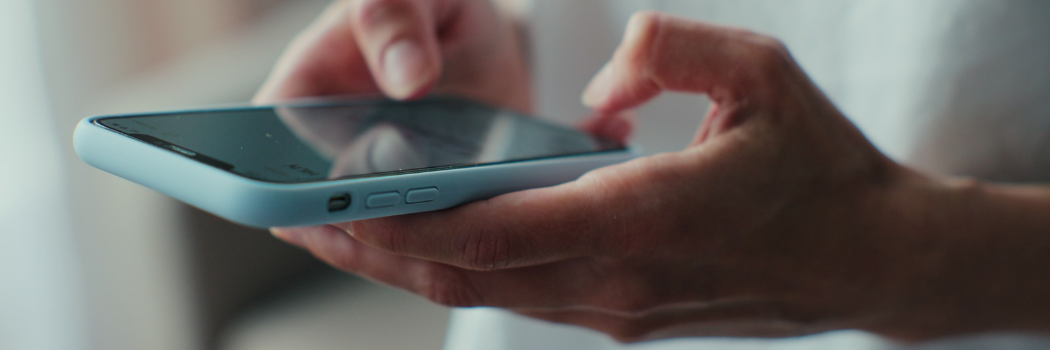 A person using a mobile phone, close up image of their hands and the phone