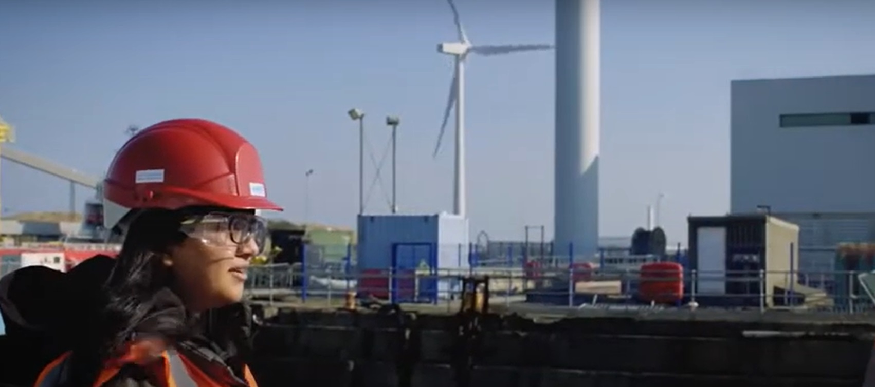 Durham researcher in front of wind turbines