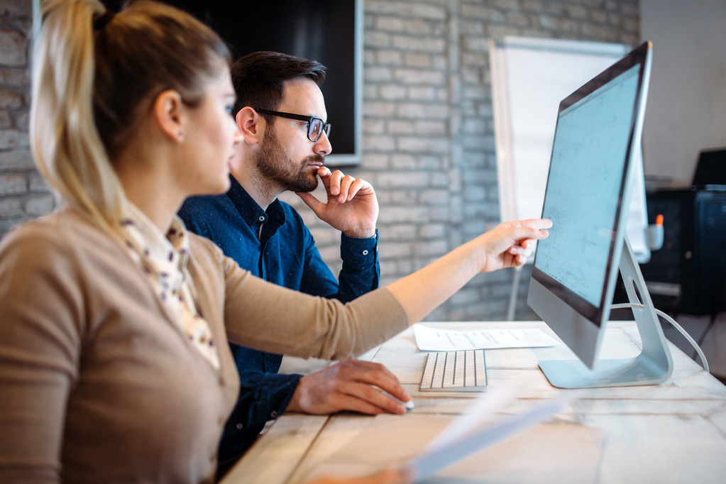 Two colleagues working together at a desktop