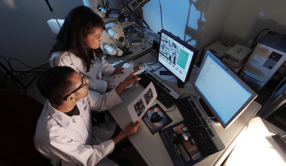 Two students in a laboratory with a computer screen.
