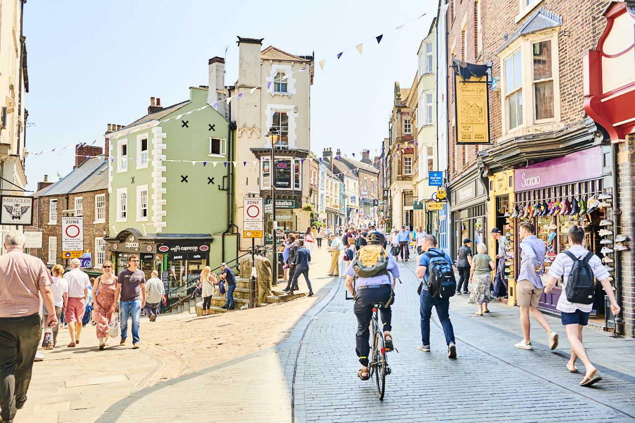 A historic street with pedestrians and a cyclist
