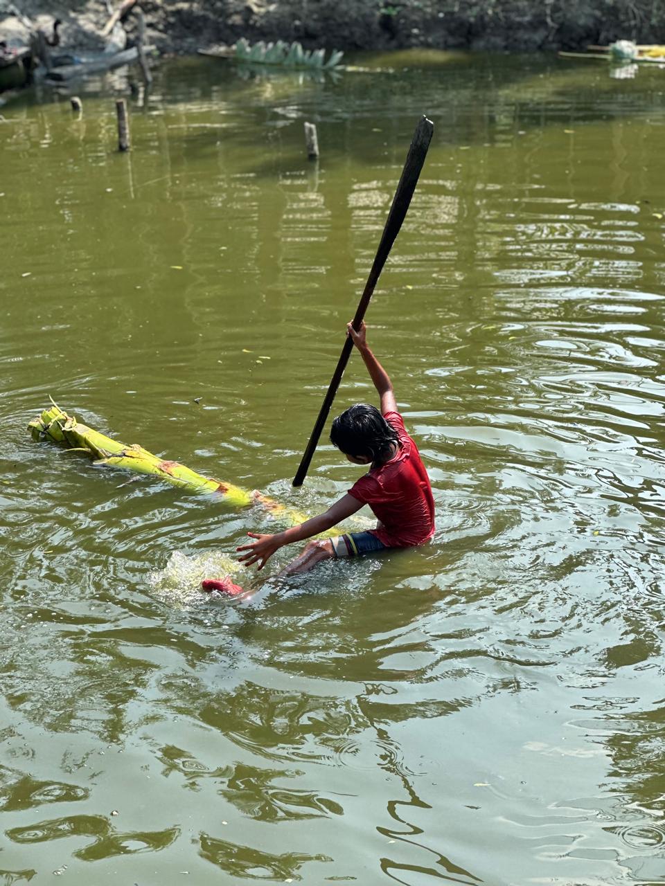 Person fishing in sinking boat in Bangladesh