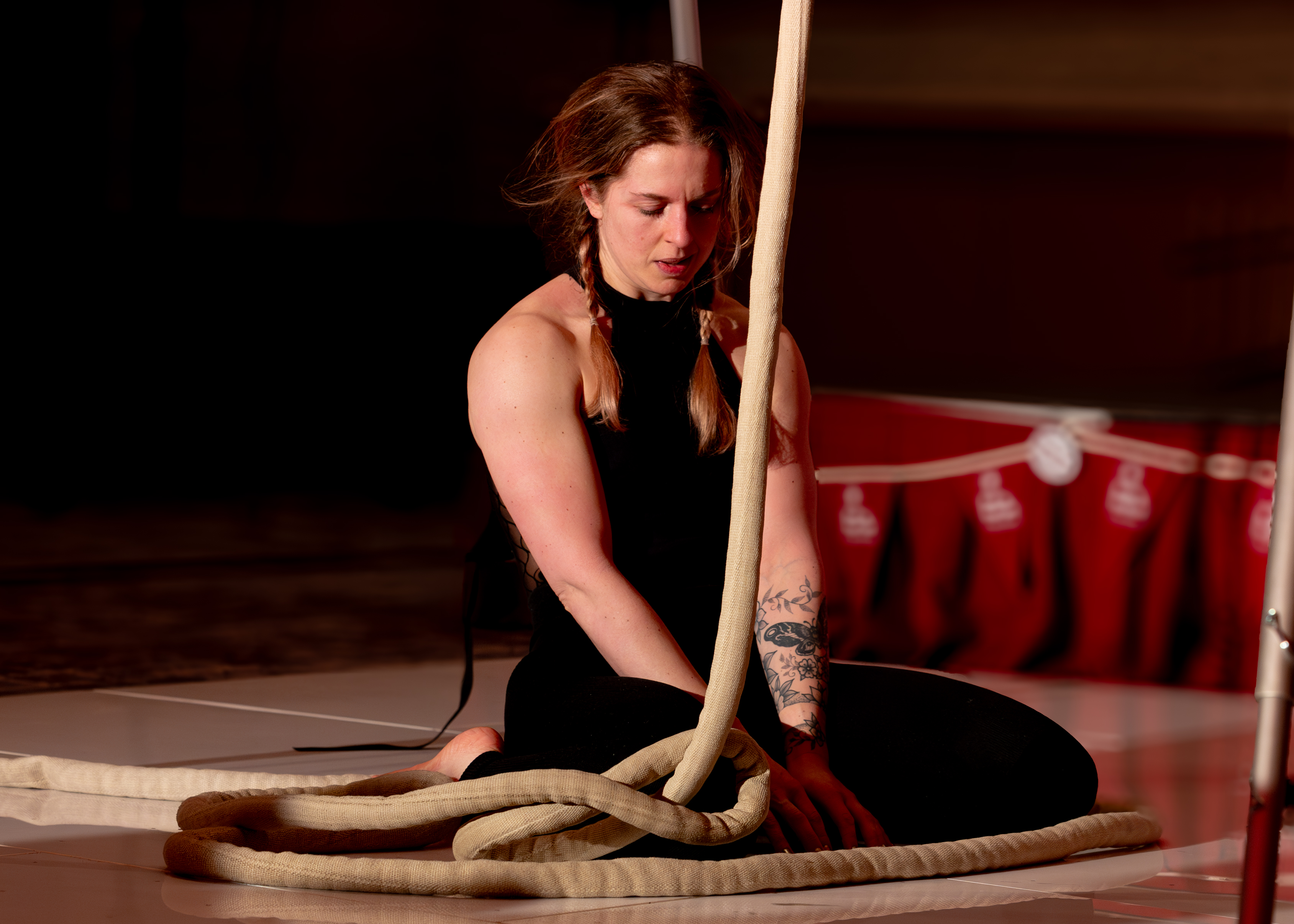 Amy Pearson sat on the floor at the beginning of an aerial performance with ropes.