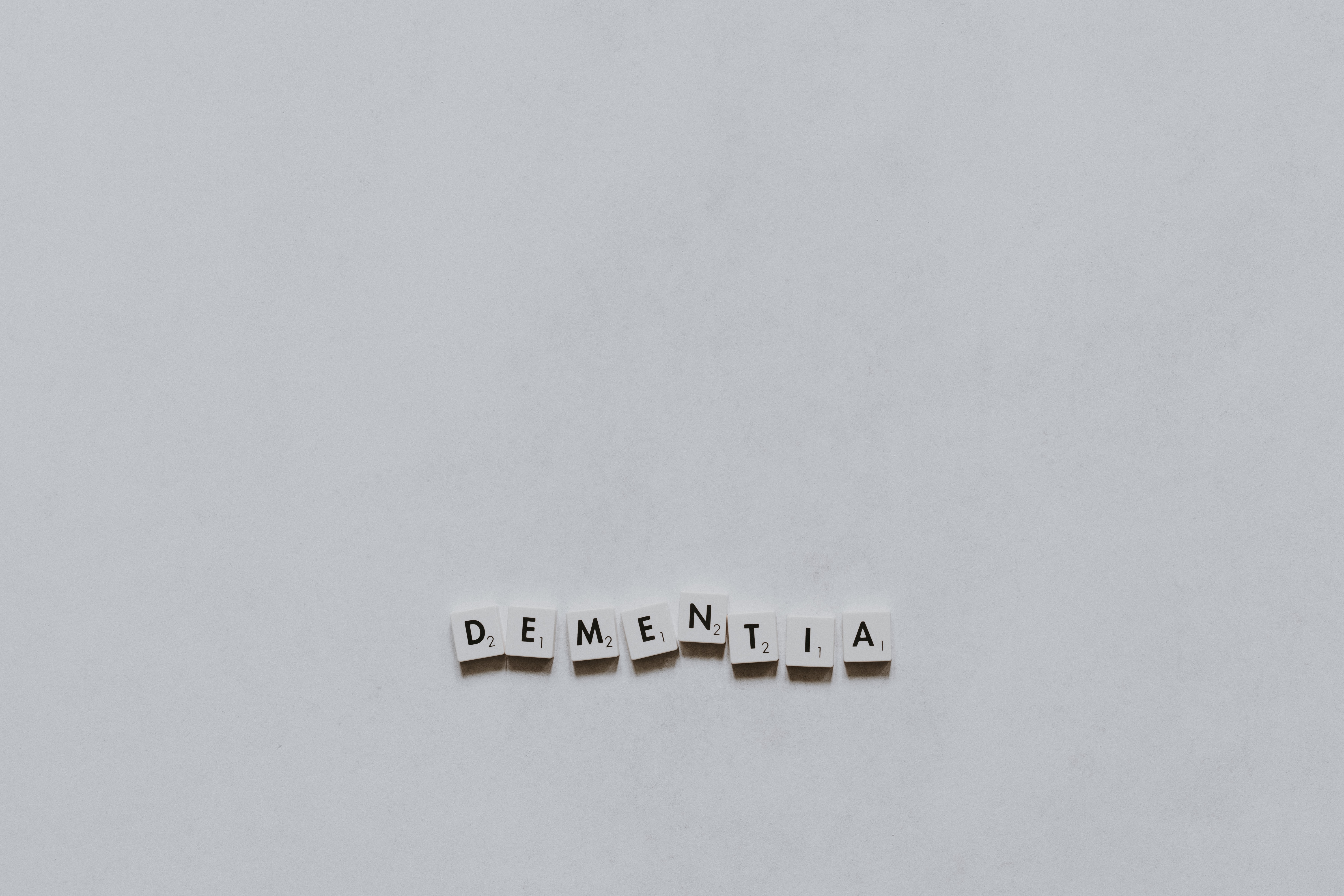 a black and white photograph of scrabble tiles spelling dementia