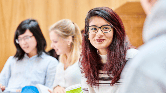 TStudent smiling with students in the background