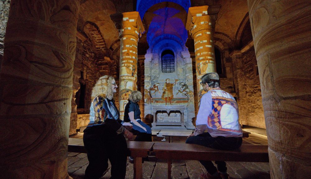Visitors watching the Jewel of the North light projection exhibition in the Norman Chapel of Durham Castle