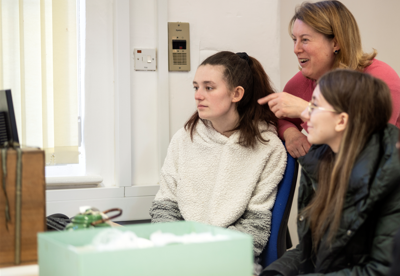 Image of a member of staff showing a researcher how to use the catalogue