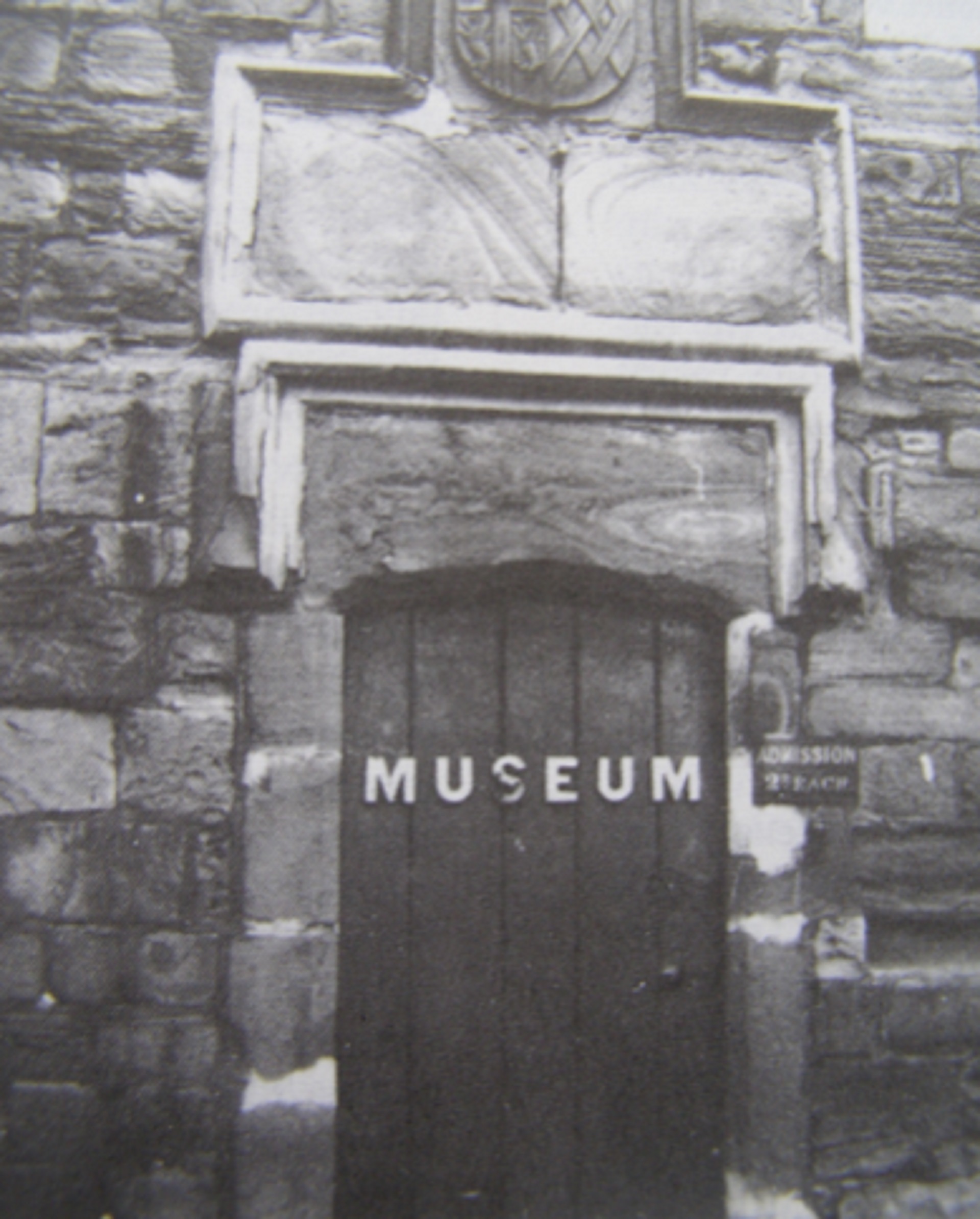 Black and white photograph with a door at the centre, and the word Museum written on it.