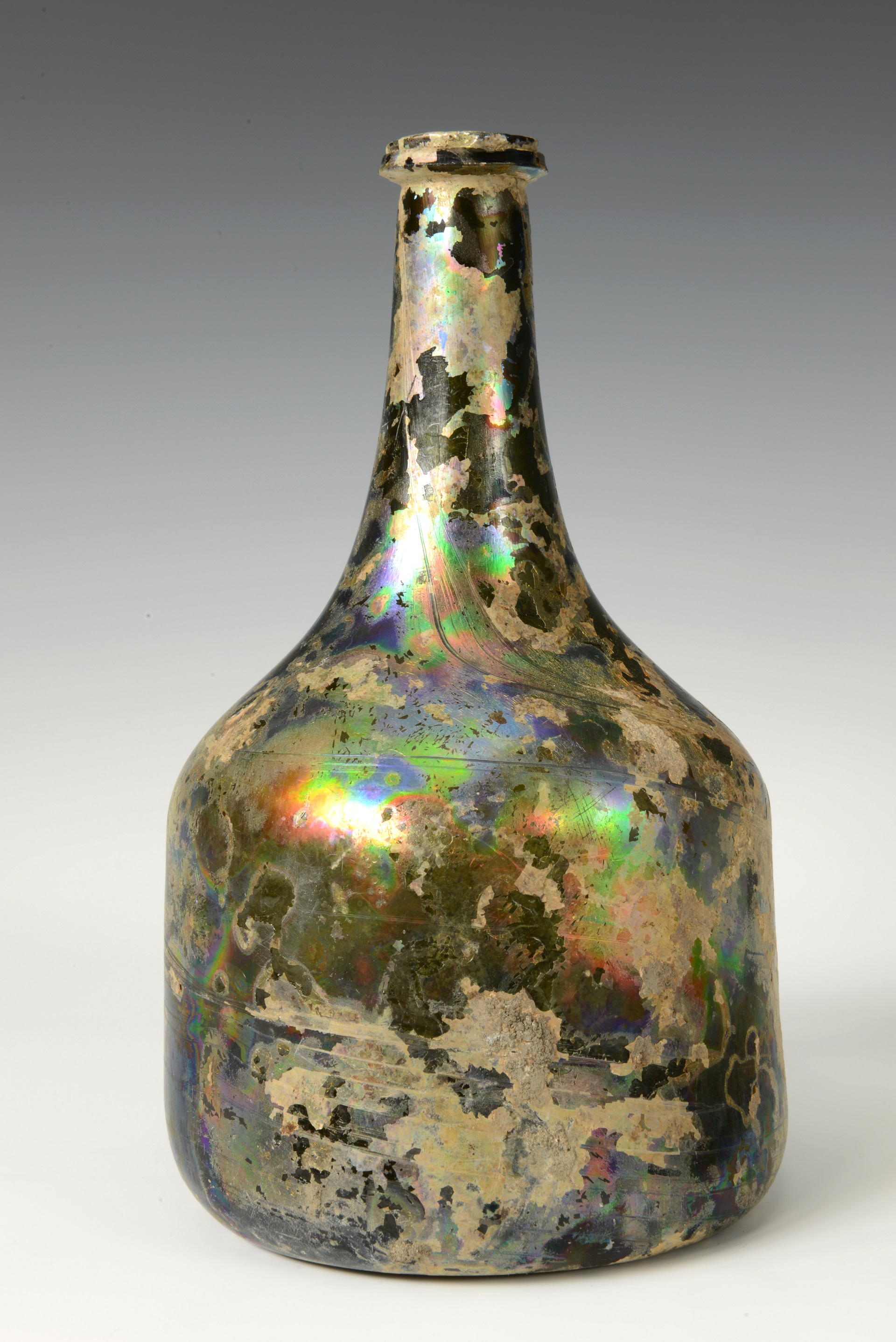 A coloured photograph of a glass bottle with an iridescent surface.