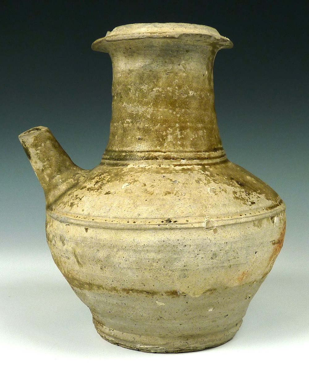 A brown jug with a rounded body and spout